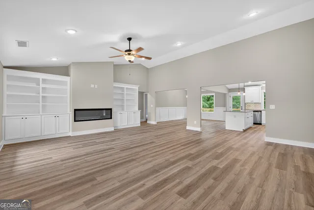 a view of an empty room with a fireplace and a window