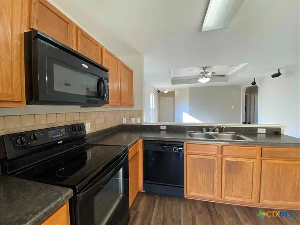 a kitchen with granite countertop a stove and cabinets