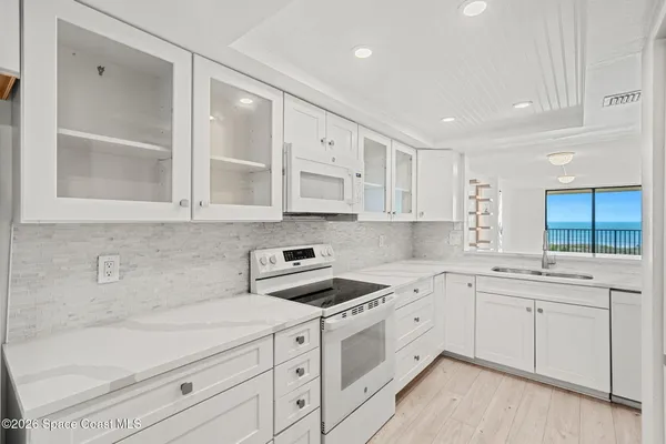 a kitchen with cabinets appliances a sink and a window