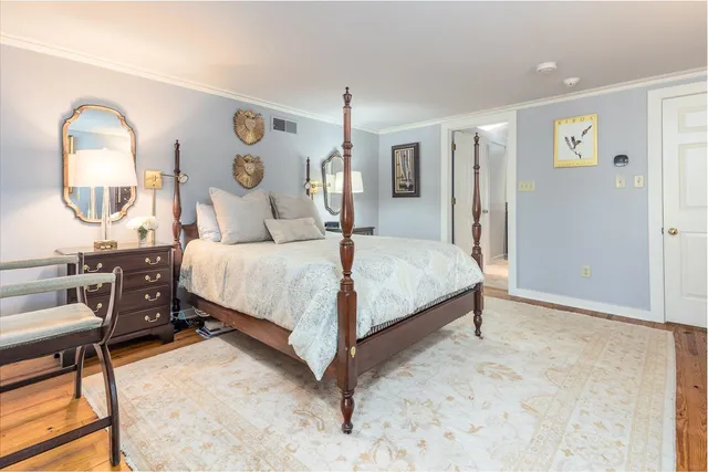 a bedroom with a bed a table and painting on the wall