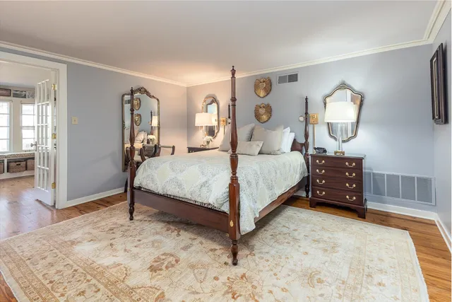 a bedroom with a bed mirror and a table