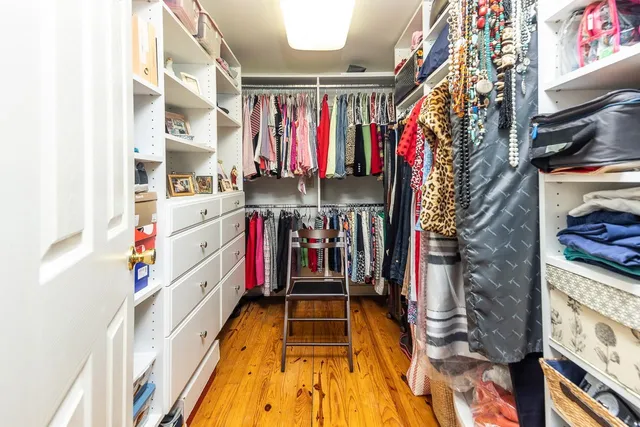a view of walk in closet with clothes and shoes