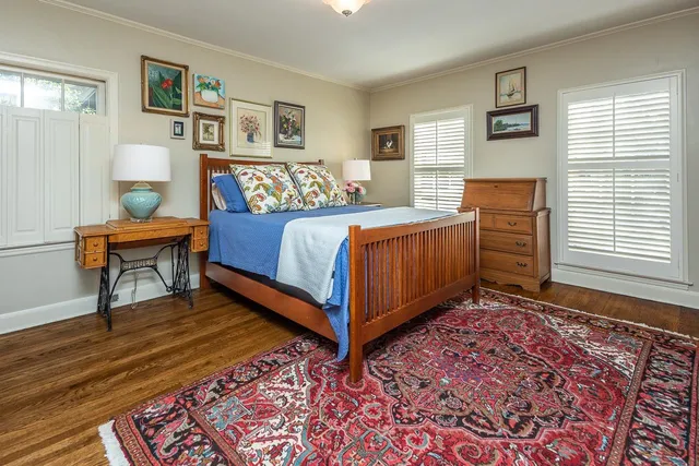 a bedroom with a bed and painting on the wall