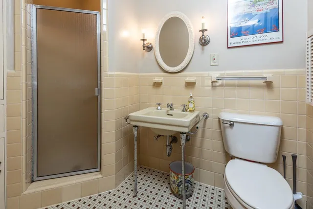 a bathroom with a toilet a sink and a mirror