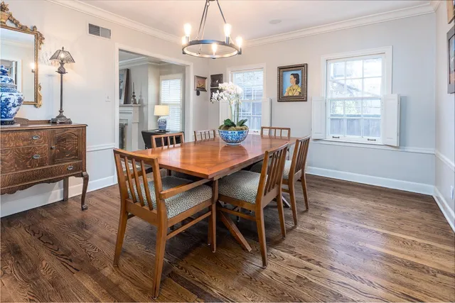 a dining room with furniture a chandelier and wooden floor
