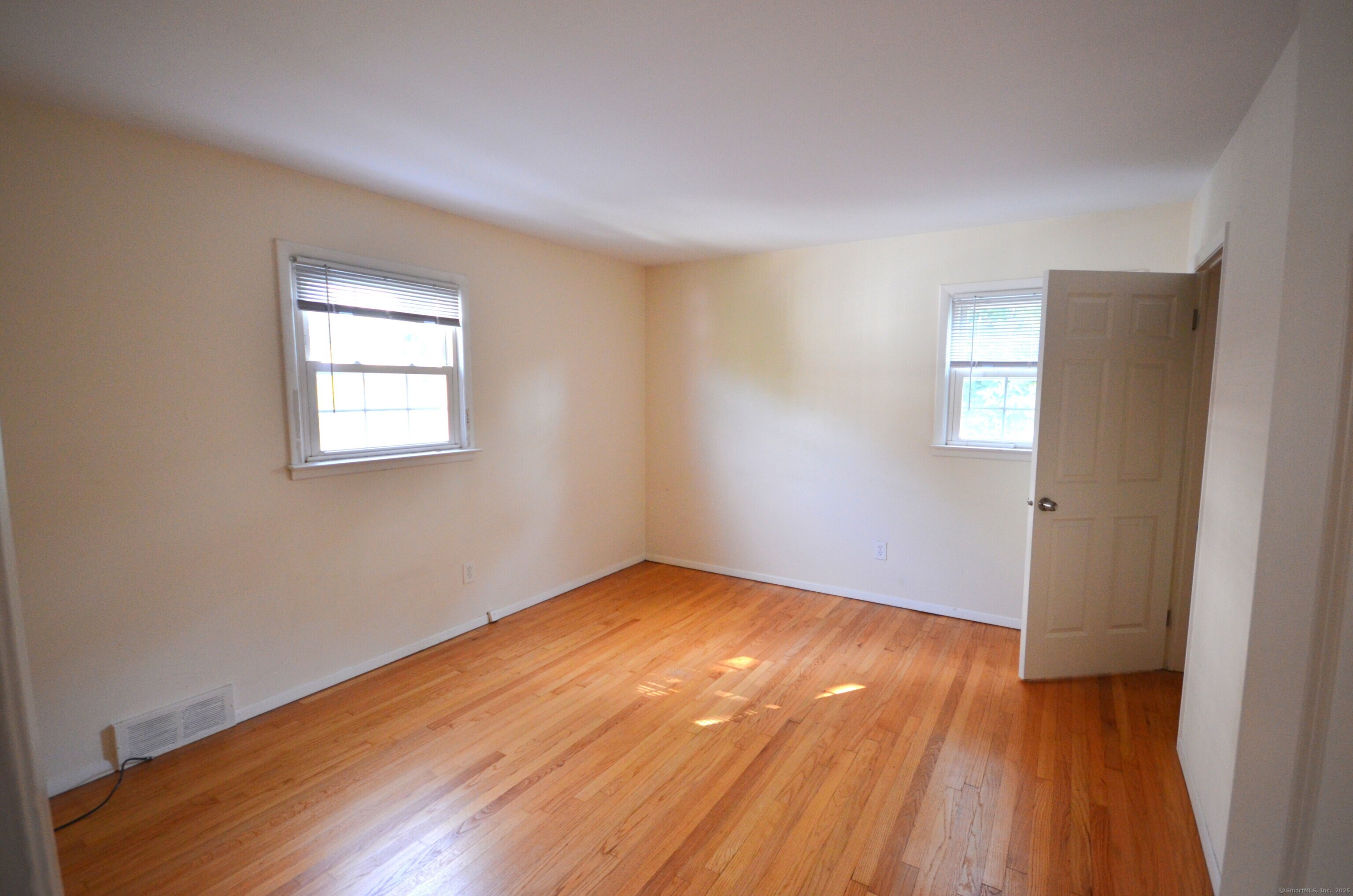 28 Riverside Drive Fairfield, CT 06824 - Photo 11 of 14 an empty room with wooden floor and windows