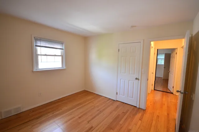 an empty room with wooden floor and a window