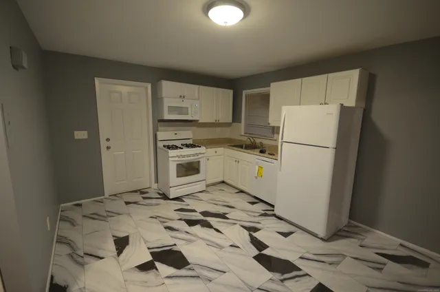 a kitchen with a refrigerator a stove top oven and cabinets