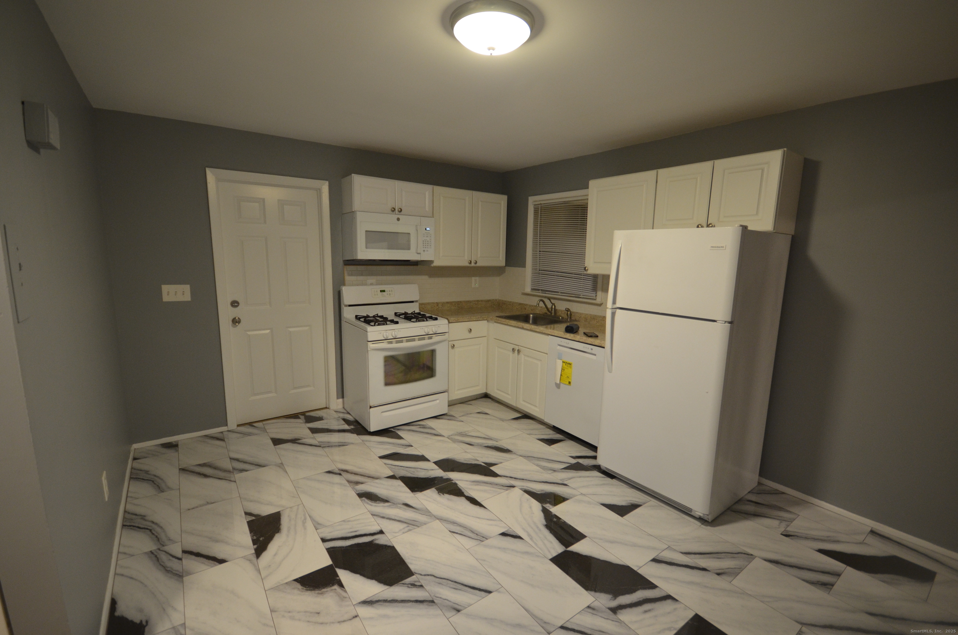 28 Riverside Drive Fairfield, CT 06824 - Photo 5 of 14 a kitchen with a refrigerator a stove top oven and cabinets