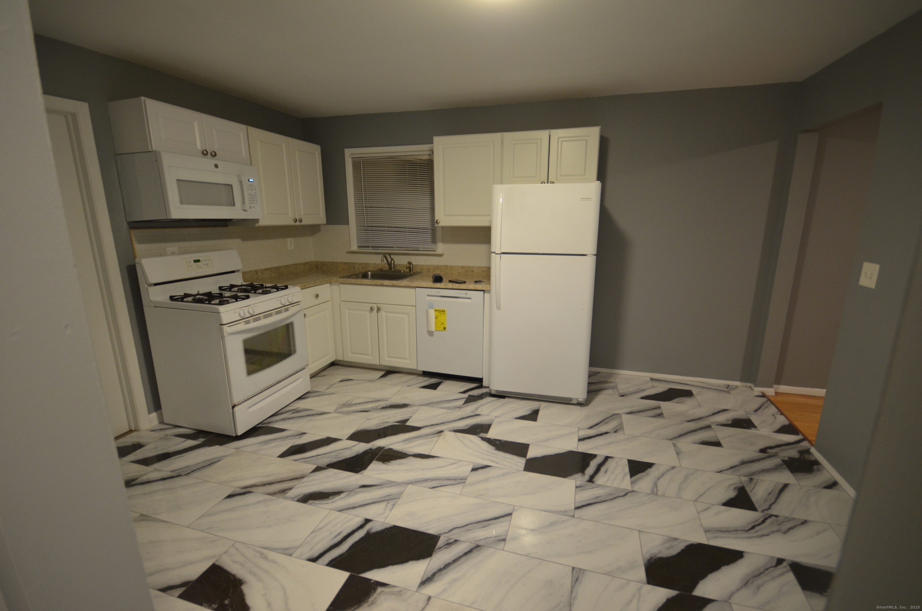 28 Riverside Drive Fairfield, CT 06824 - Photo 6 of 14 a kitchen with white cabinets and white appliances