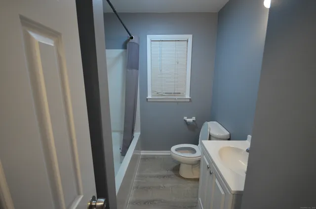 a white toilet sitting next to a shower