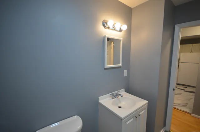 a bathroom with a toilet sink and mirror