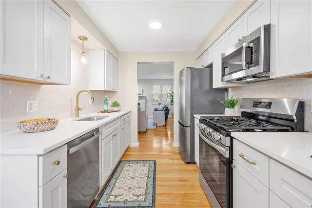 a kitchen with stainless steel appliances granite countertop a stove a sink and a refrigerator