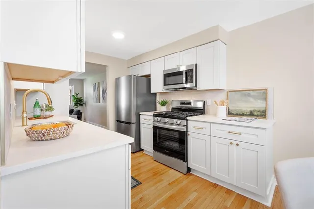 a kitchen with stainless steel appliances a stove refrigerator sink and microwave