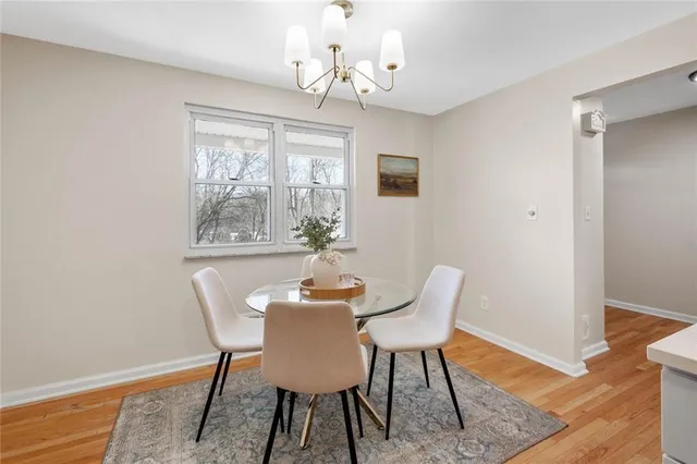 a dining room with furniture a chandelier and wooden floor