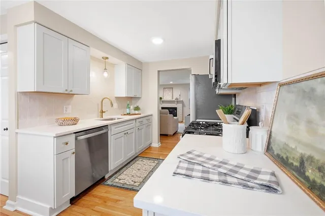 a kitchen with a sink stove and white cabinets