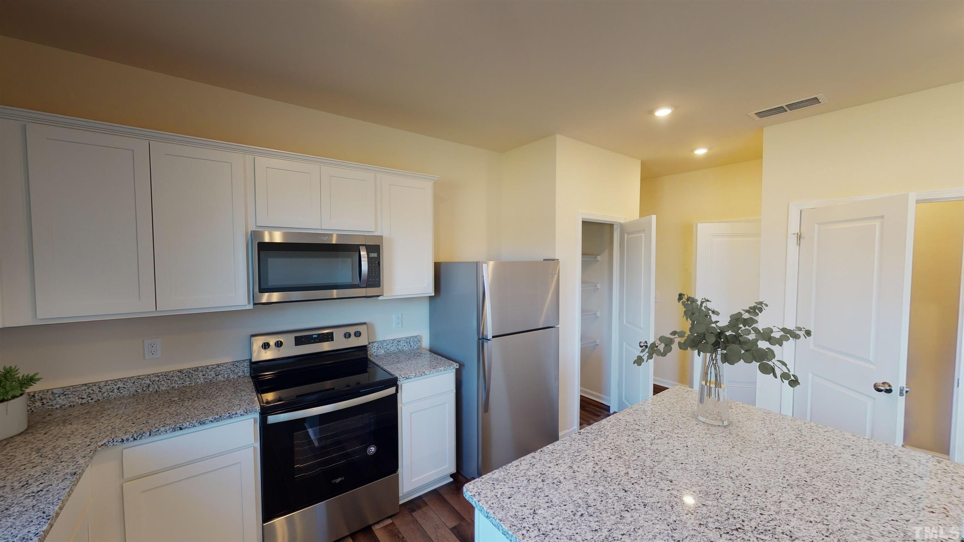 3429 Dragonfly River Raleigh, NC 27604 - Photo 14 of 27 a kitchen with stainless steel appliances a refrigerator a stove a microwave and cabinets