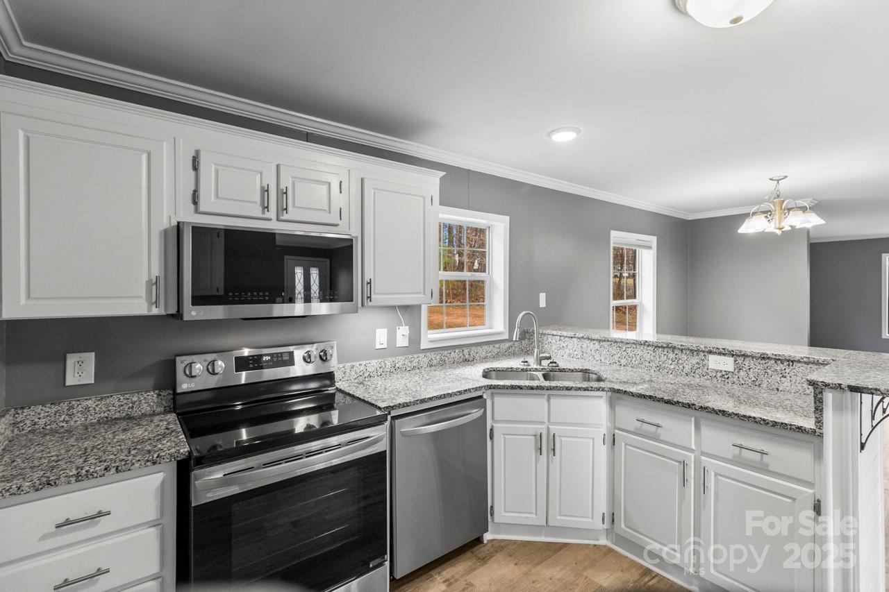 6706 Lineberger Road Denver, NC 28037 - Photo 18 of 34 a kitchen with stainless steel appliances granite countertop a sink dishwasher a stove and a microwave oven with cabinets