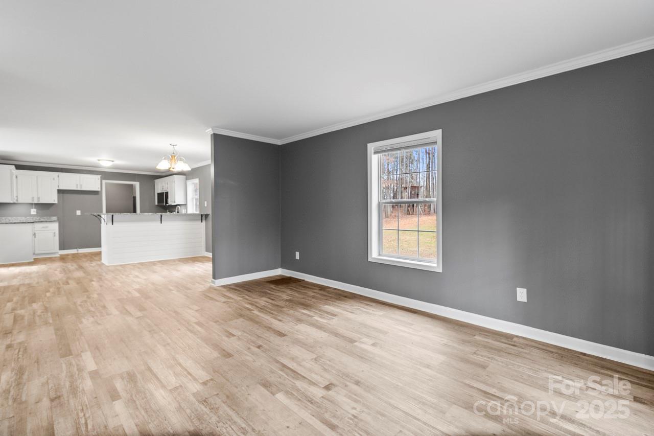 6706 Lineberger Road Denver, NC 28037 - Photo 21 of 34 a view of empty room with wooden floor and kitchen