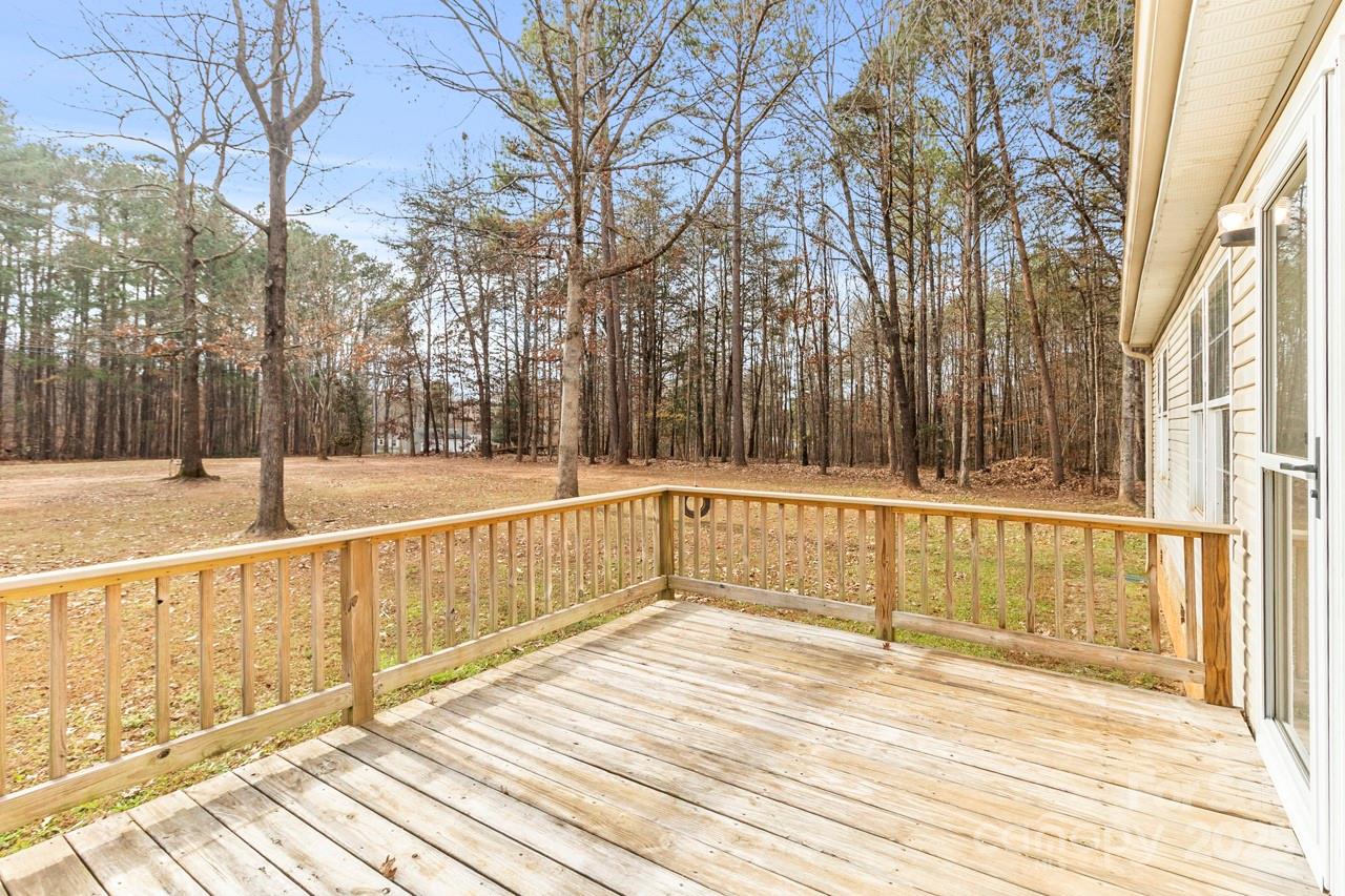 6706 Lineberger Road Denver, NC 28037 - Photo 8 of 34 a view of a balcony with large trees and wooden fence