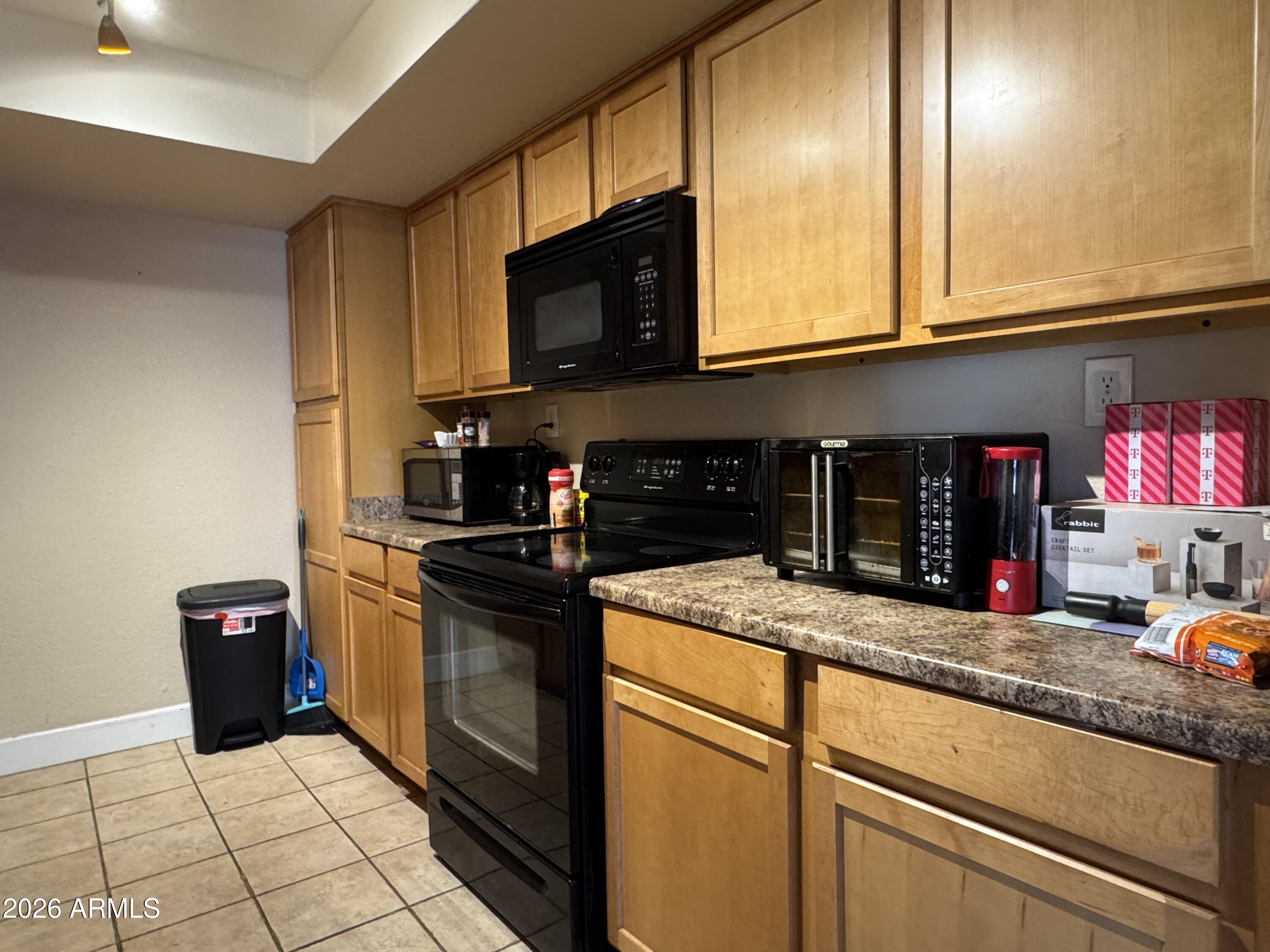 3825 East Camelback Road, Unit 276 Phoenix, AZ 85018 - Photo 2 of 12 a kitchen with stainless steel appliances granite countertop a sink and a microwave