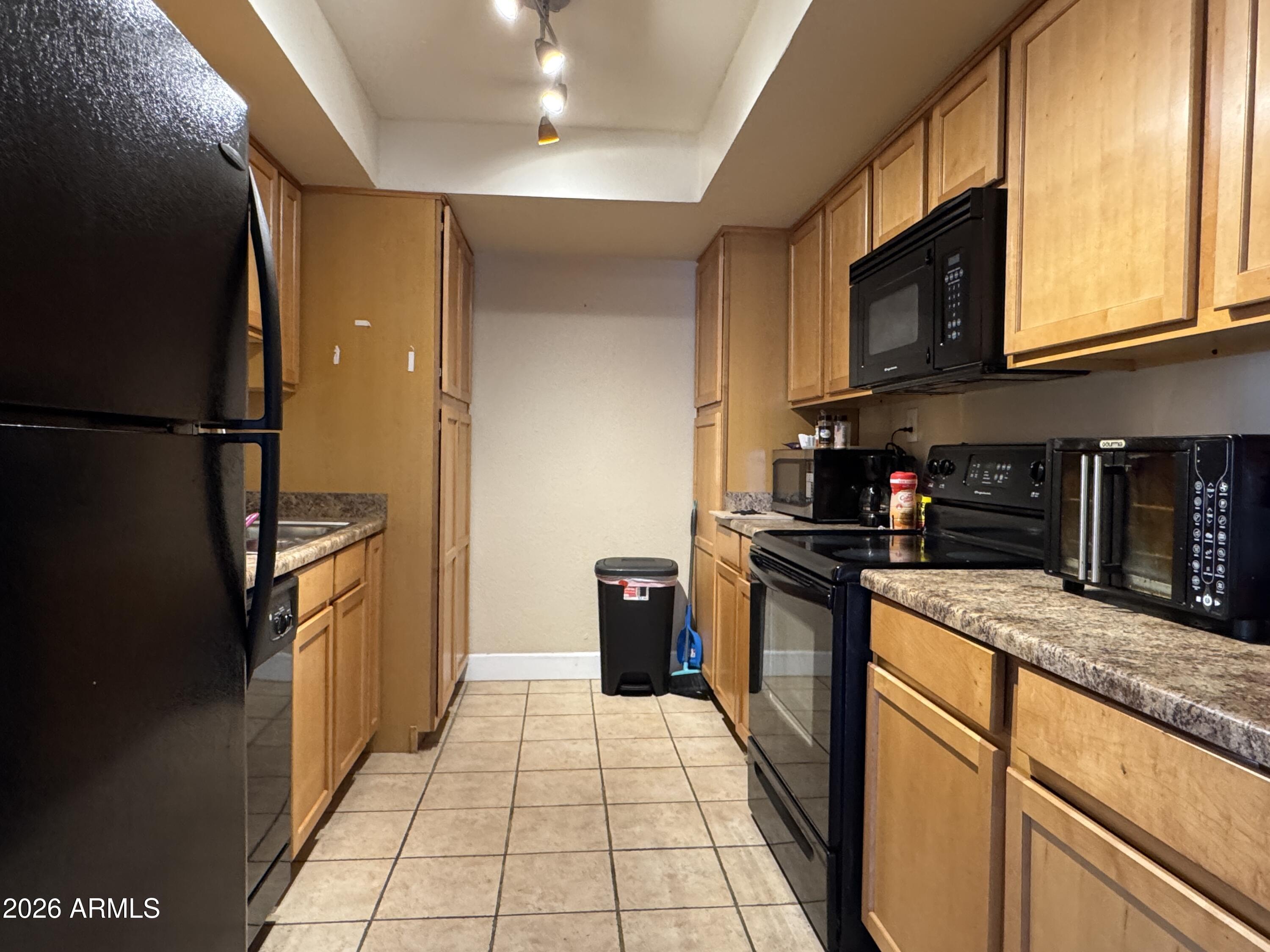 3825 East Camelback Road, Unit 276 Phoenix, AZ 85018 - Photo 3 of 12 a kitchen with stainless steel appliances granite countertop a refrigerator a stove top oven and a sink
