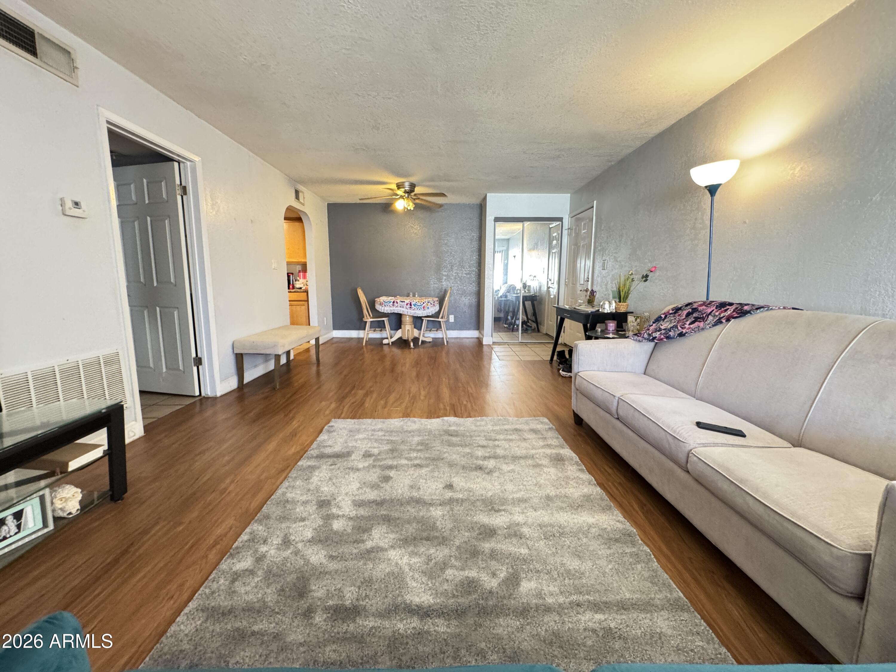 3825 East Camelback Road, Unit 276 Phoenix, AZ 85018 - Photo 6 of 12 a living room with furniture and a wooden floor