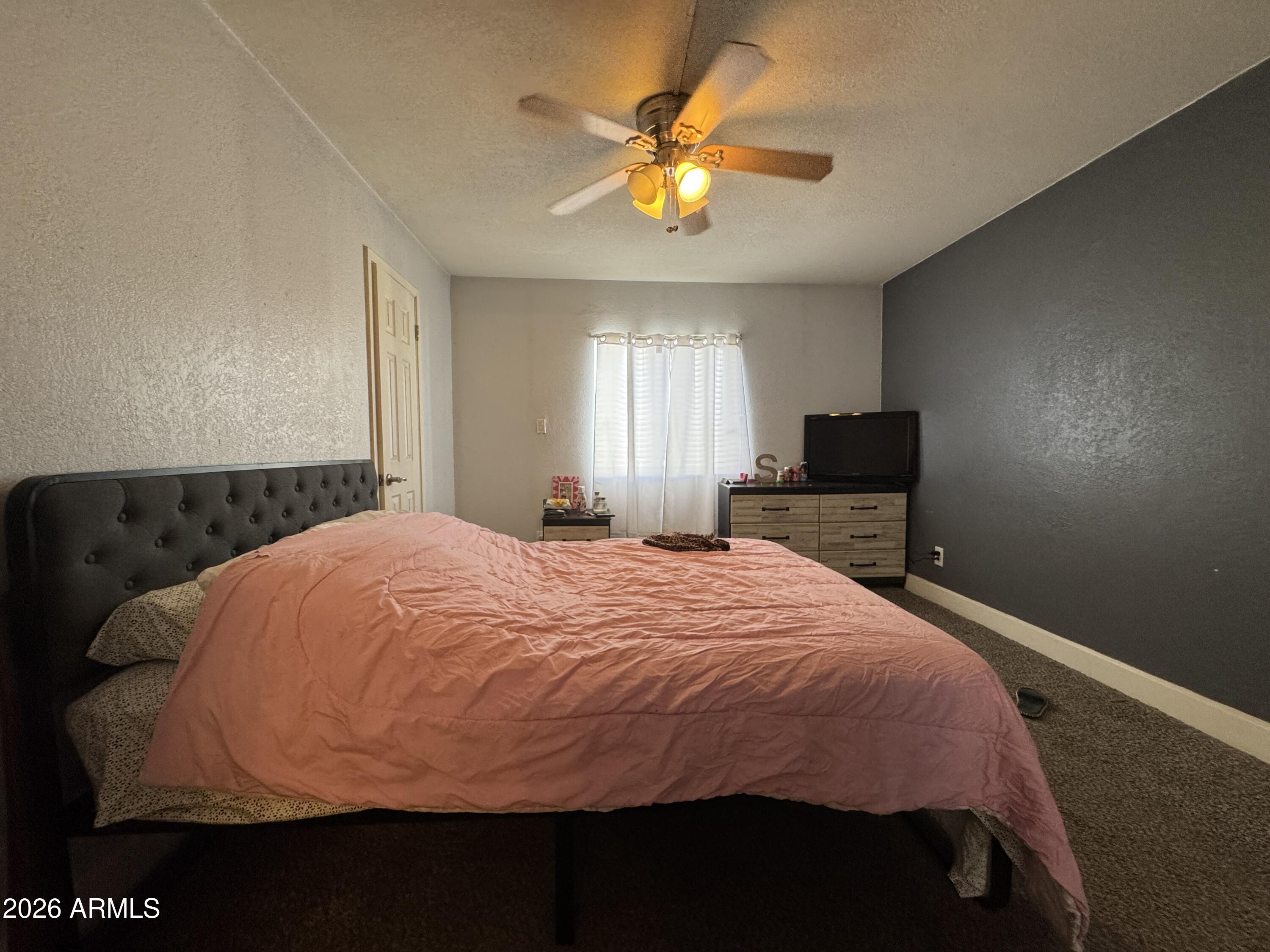 3825 East Camelback Road, Unit 276 Phoenix, AZ 85018 - Photo 9 of 12 a bedroom with a bed and a chandelier