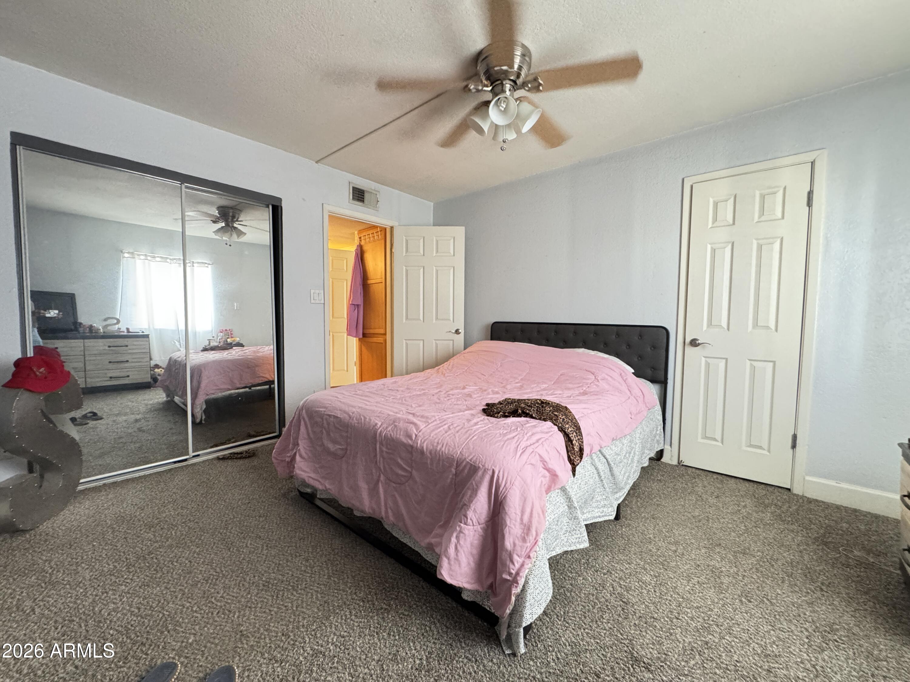 3825 East Camelback Road, Unit 276 Phoenix, AZ 85018 - Photo 10 of 12 a bedroom with a bed and a chandelier