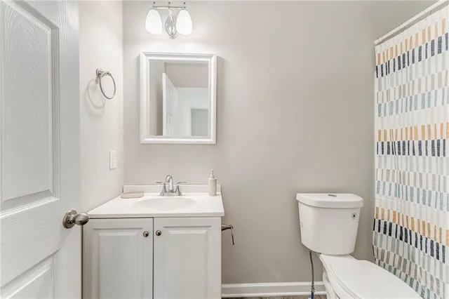 a bathroom with a toilet a sink and mirror