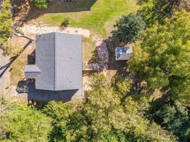 a view of a house with a yard and large trees