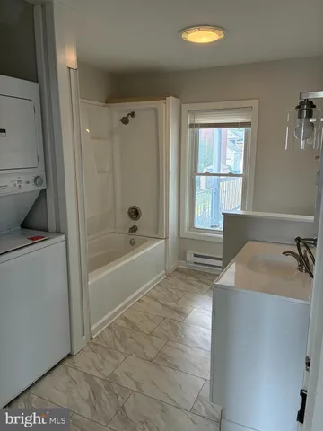 a bathroom with a tub sink and mirror