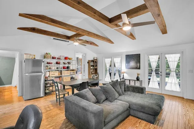 a living room with furniture and a wooden floor