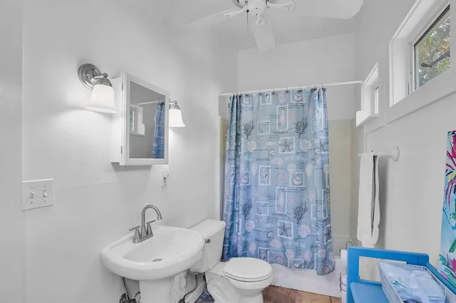 a bathroom with a sink toilet a mirror and shower