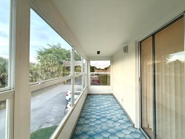 a view of a large room with wooden floor and windows