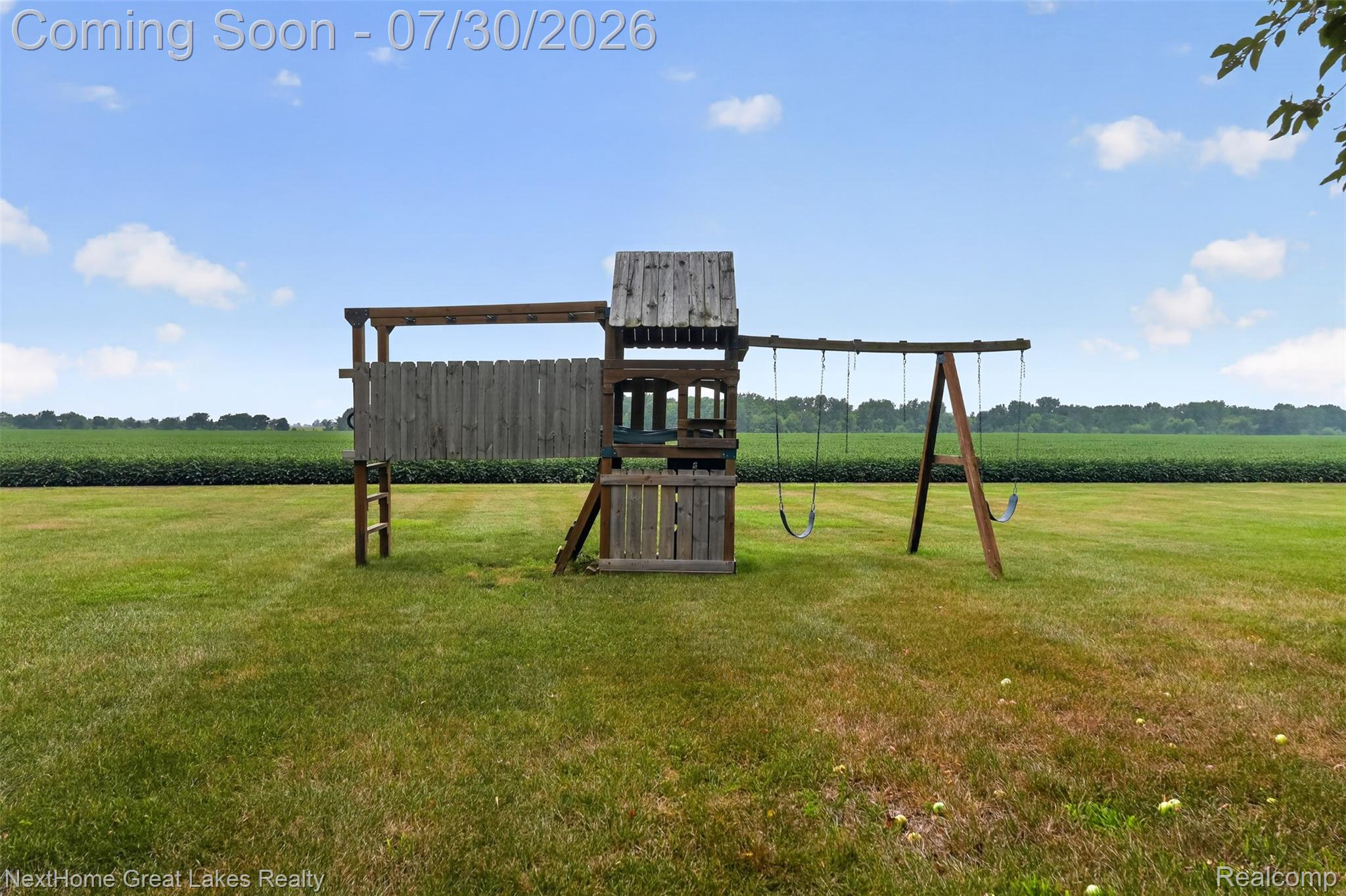 6249 North New Lothrop Road New Lothrop, MI 48460 - Photo 43 of 50 Expansive green lawn with a wooden playset featuring a tower, ladder, and swing set