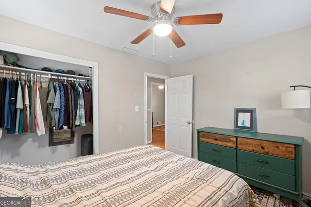 a bedroom with a bed and a flat tv screen on dresser