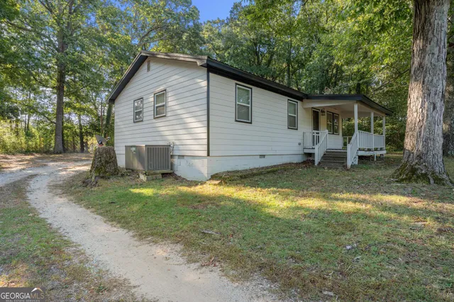 a view of a house with backyard and chairs