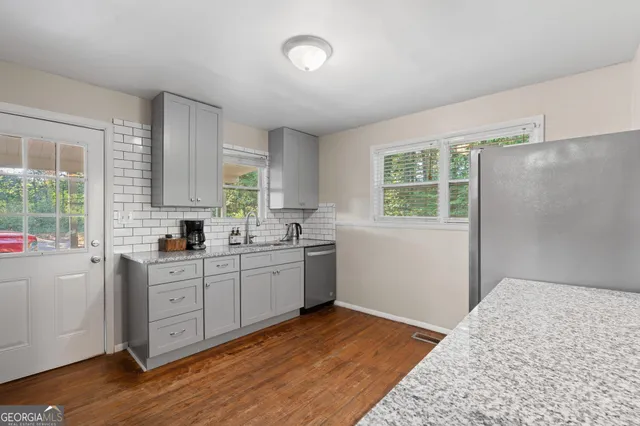 a kitchen with a sink cabinets appliances and a window