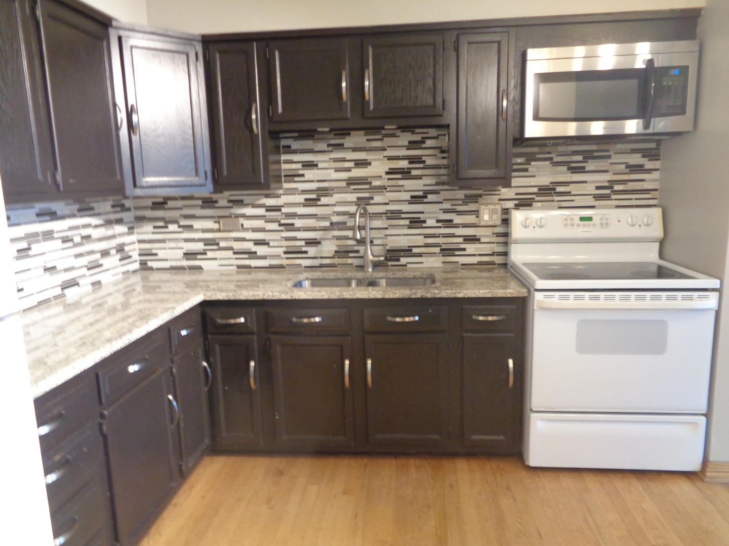 6233 West 94th Street, Unit 1SE Oak Lawn, IL 60453 - Photo 6 of 13 a kitchen with stainless steel appliances wooden cabinets and a sink