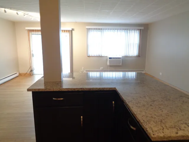 a kitchen with granite countertop sink and window