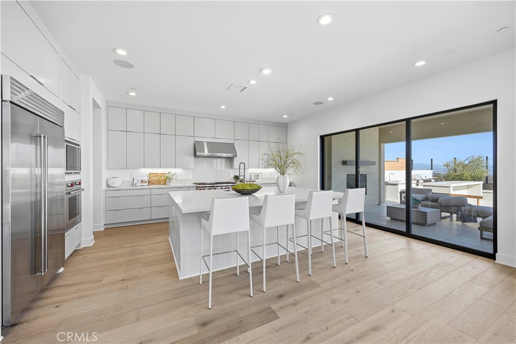 20138 Marlow Lane Porter Ranch, CA 91326 - Photo 5 of 39 a kitchen with a table chairs refrigerator and microwave