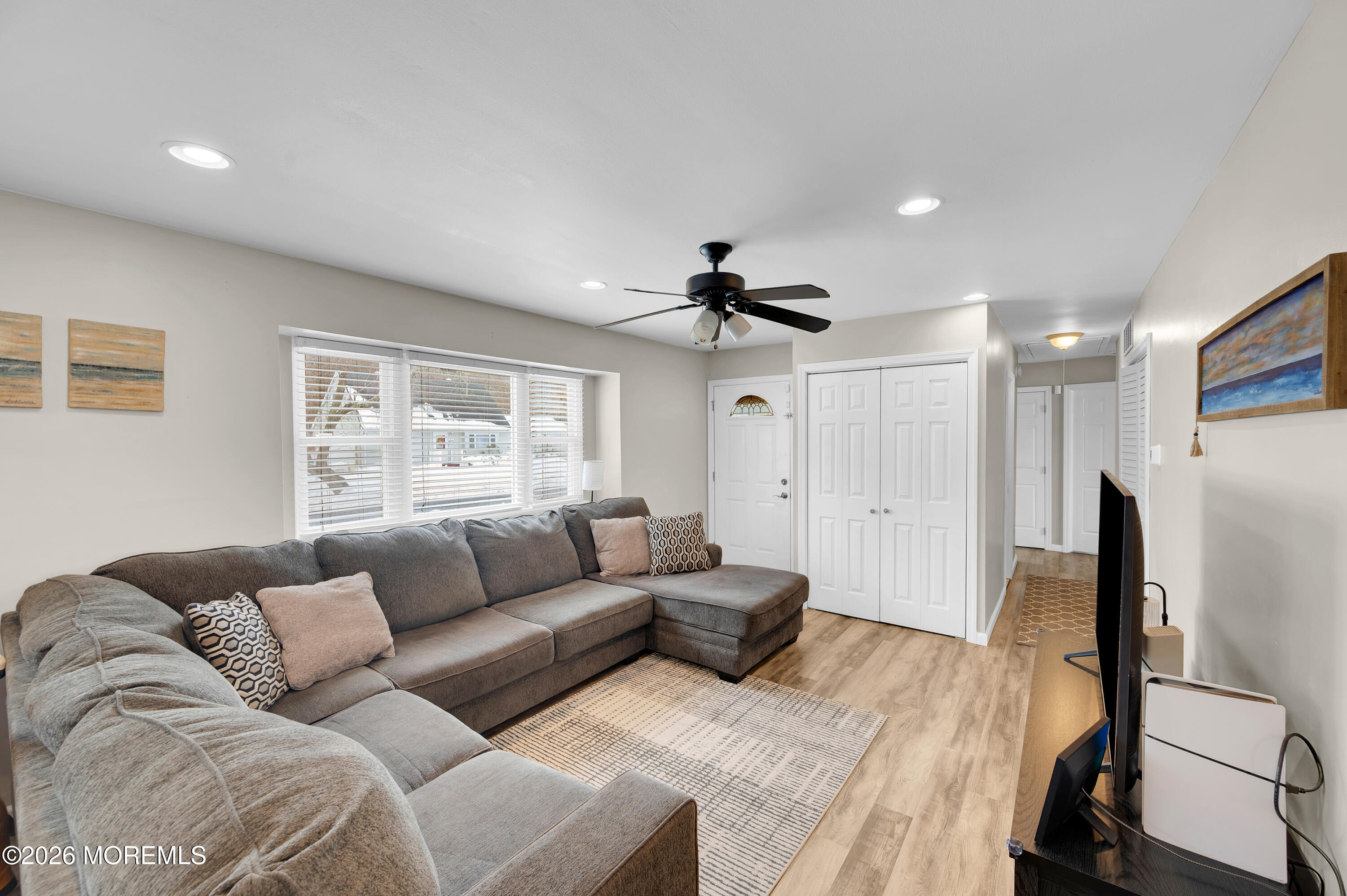 a living room with furniture and a refrigerator