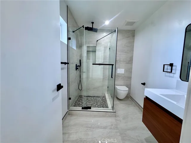 a bathroom with a granite countertop sink toilet and shower
