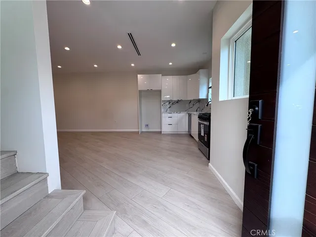 a view of a kitchen with a sink and refrigerator