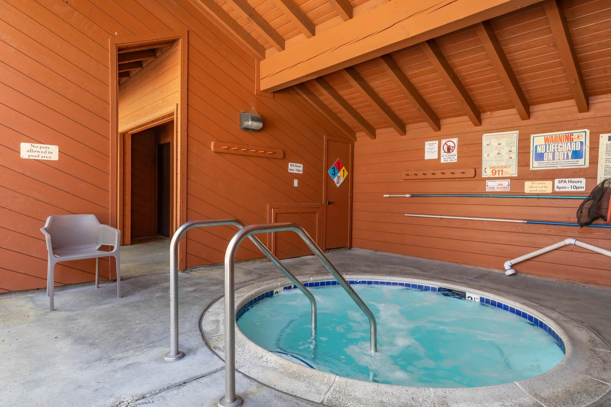 3392 Chateau Road, Unit 29 Mammoth Lakes, CA 93546 - Photo 29 of 30 Spacious covered spa area featuring an in-ground spa with grab rails, wood-paneled walls, and an exp