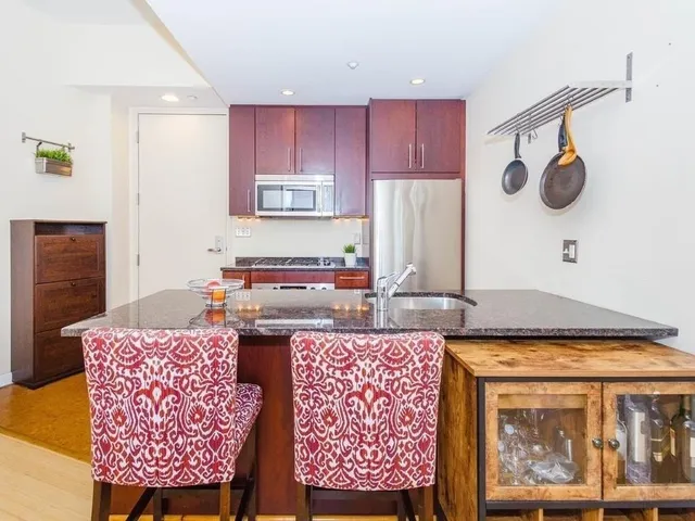 a kitchen with a stove a refrigerator and a table