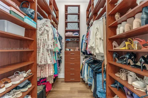 a view of walk in closet with clothes and shoes