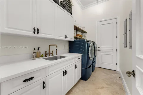 a utility room with cabinets washer and dryer