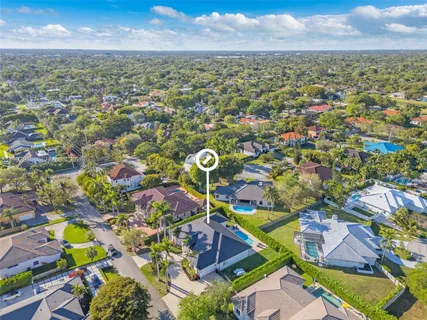 an aerial view of residential houses with outdoor space and trees